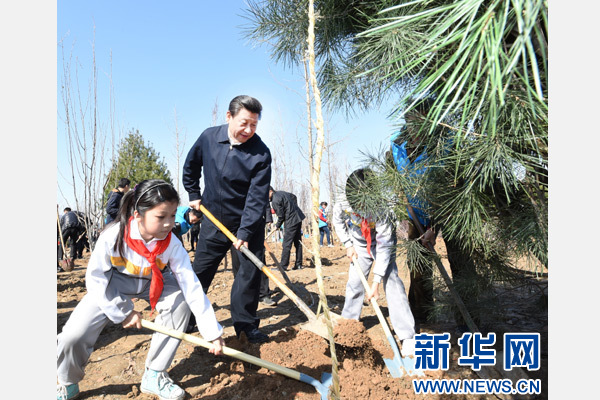 这是习近平同大家一起植树。 新华社记者 张铎 摄