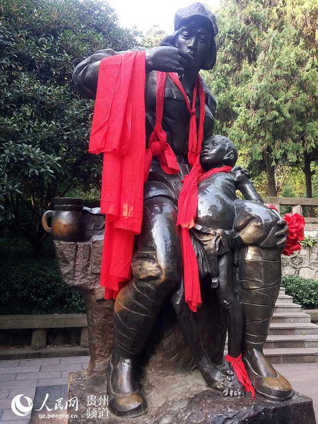 图为红军卫生员龙思泉给病人喂药铜像。