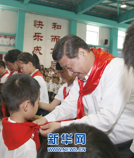 5月30日上午，中共中央总书记、国家主席、中央军委主席习近平来到北京市海淀区民族小学，参加庆祝“六一”国际儿童节活动。这是习近平在少先队入队仪式上，为新少先队员系上红领巾。新华社记者 鞠鹏 摄 